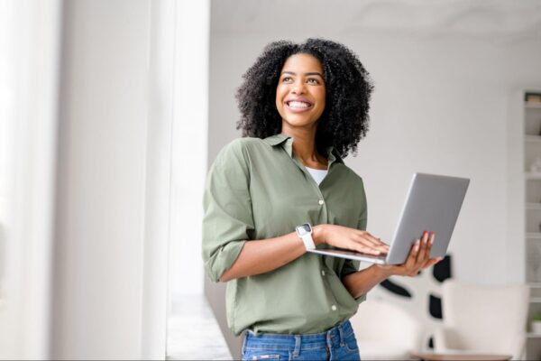 A smiling woman holding a computer