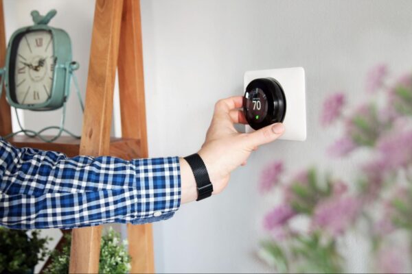 a man in his house adjusting the temperature